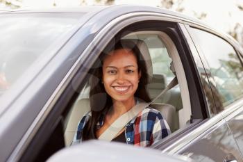 Happy Hispanic female driver in a car
