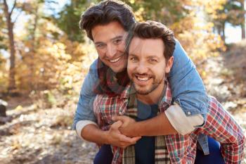 Portrait Of Gay Male Couple Walking Through Fall Woodland