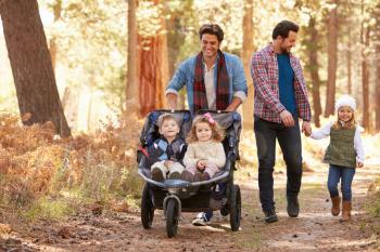 Gay Male Couple Pushing Children In Buggy Through Woods