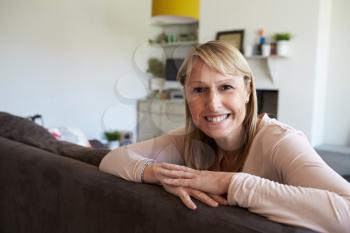 Portrait Of Mature Woman Relaxing On Sofa At Home