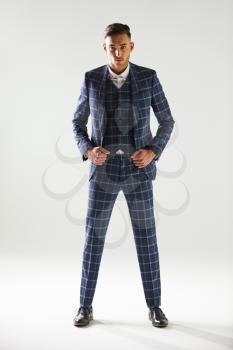 Full length portrait of young man wearing checked suit
