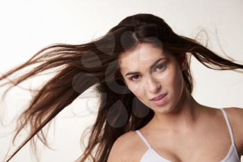 Dark haired, late teen girl with hair blowing, horizontal