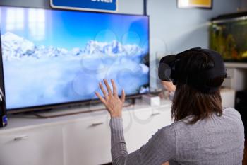 Woman Watching Television Wearing Virtual Reality Headset
