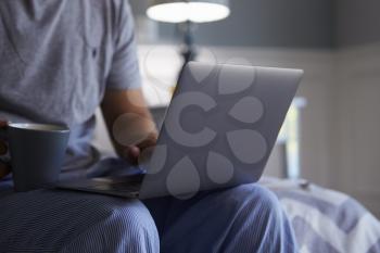 Close Up Of Man In Pajamas Using Laptop Computer