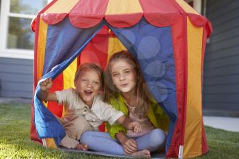 Two Children Playing Inside Tent In Garden Together