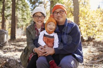 Portrait of Asian parents and young daughter in a forest