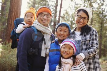 Portrait of an Asian family of five in a forest setting