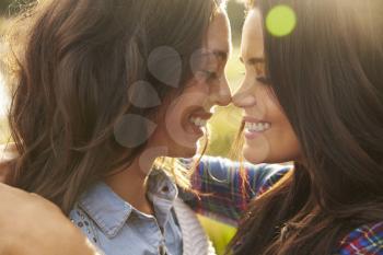 Lesbian couple embrace touching noses, eyes closed, close up