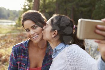 Lesbian couple in the countryside kiss and take a selfie