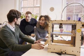 Team Of Designers Working With 3D Printer In Design Studio