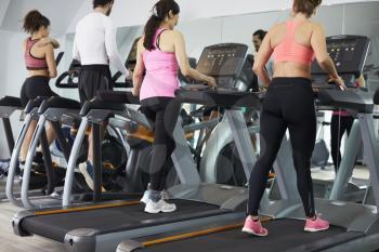 People Using Equipment In Busy Gym