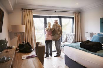 Senior Couple Arriving In Hotel Room On Vacation