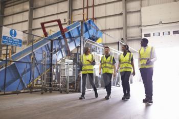 Staff wearing reflective vests in an industrial interior