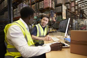 Staff discuss warehouse logistics in an on-site office
