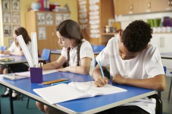 Two primary school pupils working at their desks in class