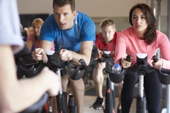 Spinning class on exercise bikes at a gym, close up