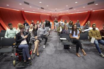 Students sit facing camera in a modern university classroom