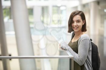 Smiling dark haired female student in university building