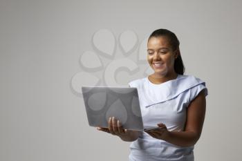 Studio Portrait Of Businesswoman Using Laptop