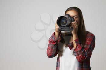 Studio Portrait Of Female Photographer With Camera