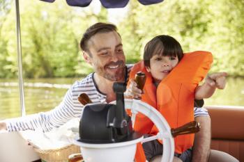 Father And Son Enjoying Day Out In Boat On River Together