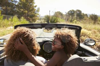 Woman embraces her partner as he drives, rear passenger POV