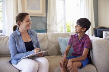 Young Boy Talking With Counselor At Home