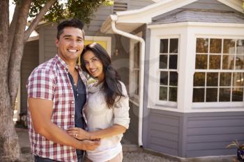 Portrait Of Couple Standing Outside Home