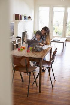 Mother And Daughter Using Laptop At Home Together
