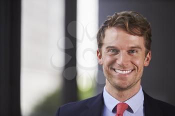 Young white businessman smiling, close up