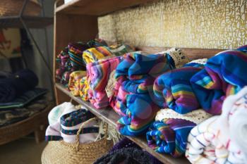 Colourful blankets displayed on shelves in a store, close up