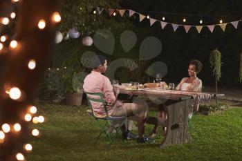 Young black couple relaxing at dinner in a garden