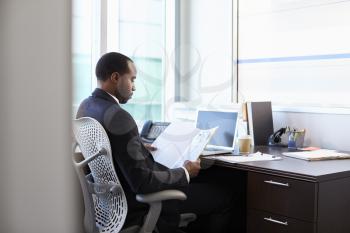 Doctor Working Reading Notes At Desk In Office