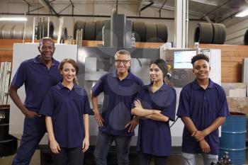 Portrait Of Engineers And Apprentices With CNC Machine