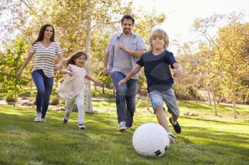 Family Playing Soccer In Park Together