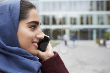 British Muslim Woman Using Mobile Phone Outside Office