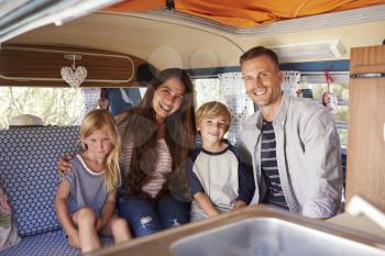 Smiling family portrait inside camper van
