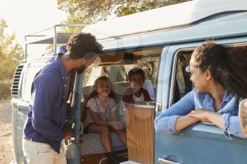 Family on a road trip making a stop in their camper van