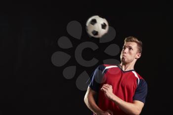 Professional Soccer Player Heading Ball In Studio