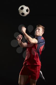 Professional Soccer Player Jumping To Head Ball In Studio