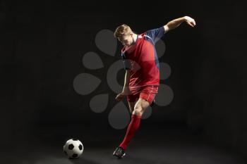 Professional Soccer Player Shooting At Goal In Studio