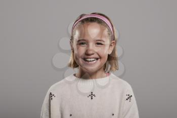 Nine year old girl smiling to camera, head and shoulders