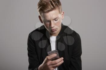 White teenage boy using mobile phone, waist up, horizontal