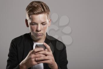 White teenage boy using mobile phone, waist up