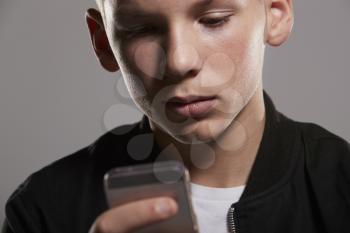 White teenage boy using mobile phone, close up, horizontal