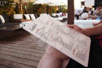 BARCELONA - JULY 29, 2016: Customer holds La Isabela Hotels rooftop bar menu, mid section