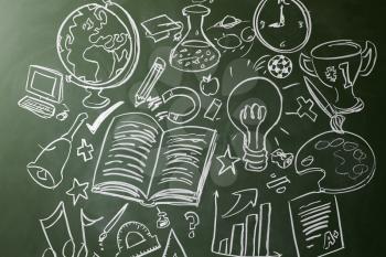 Hand drawn symbols of school subjects on a chalkboard