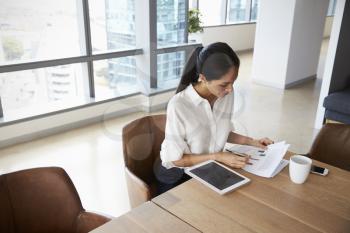 Businesswoman Working On Digital Tablet In Boardroom