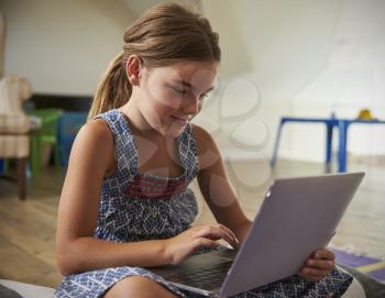 Girl Using Laptop Computer In Playroom