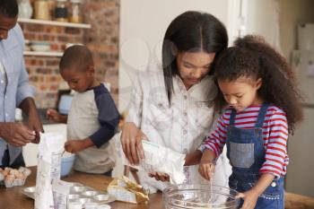 Parents And Children Baking Cakes In Kitchen Together